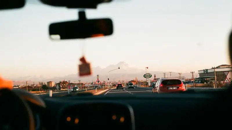 View through a car windshield of a highway at sunset
