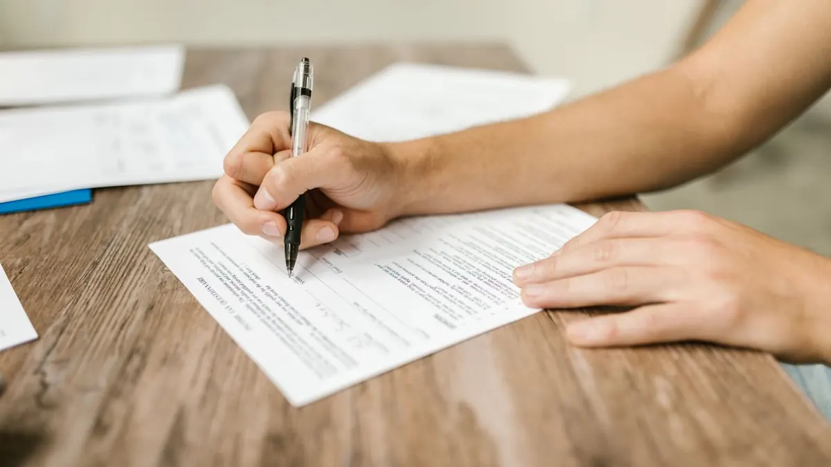 Close-Up Shot of a Person Filling Out a Form